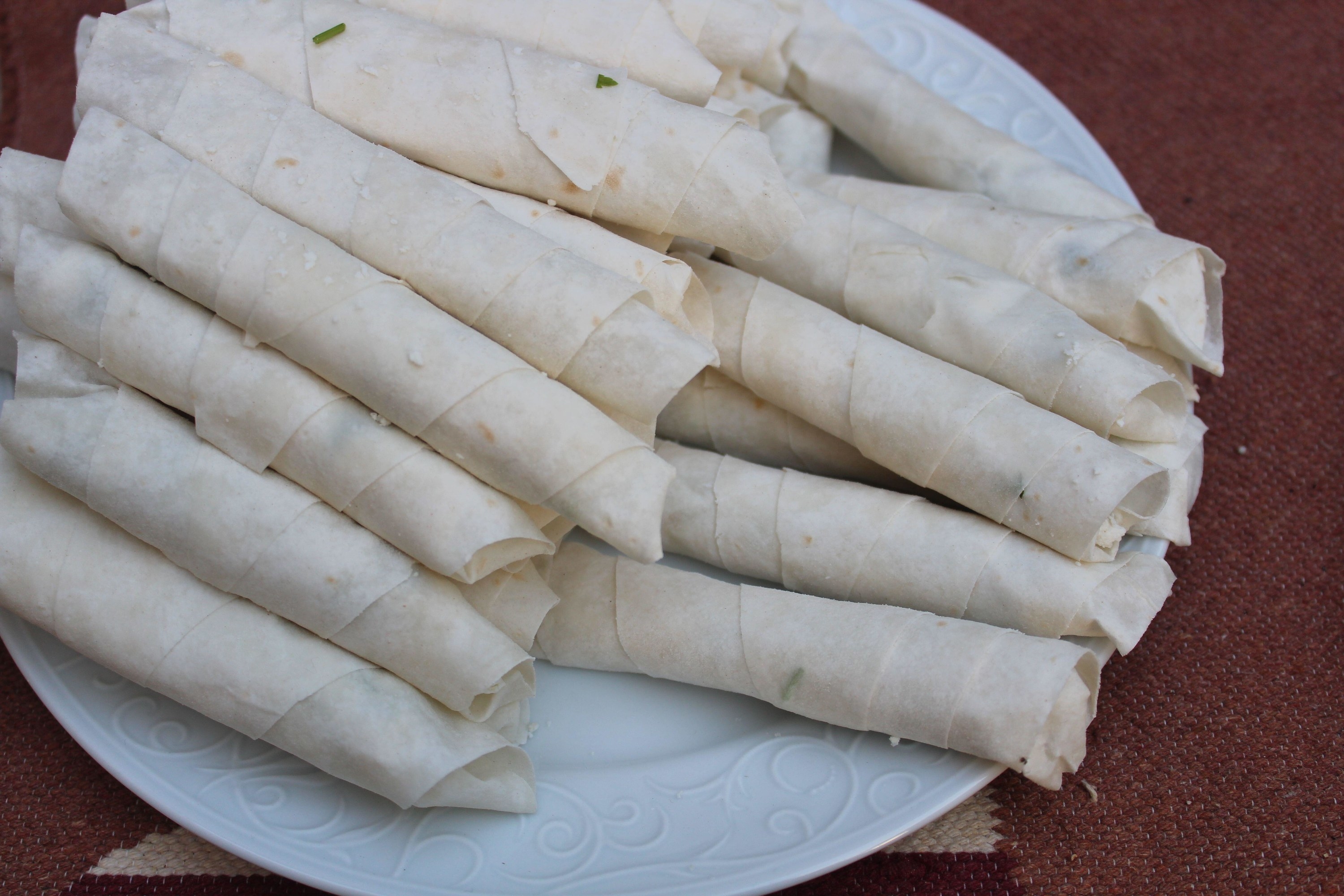 Raw cigarette shaped rolls and stuffed with meat, cheese, parsley, purslane or dill