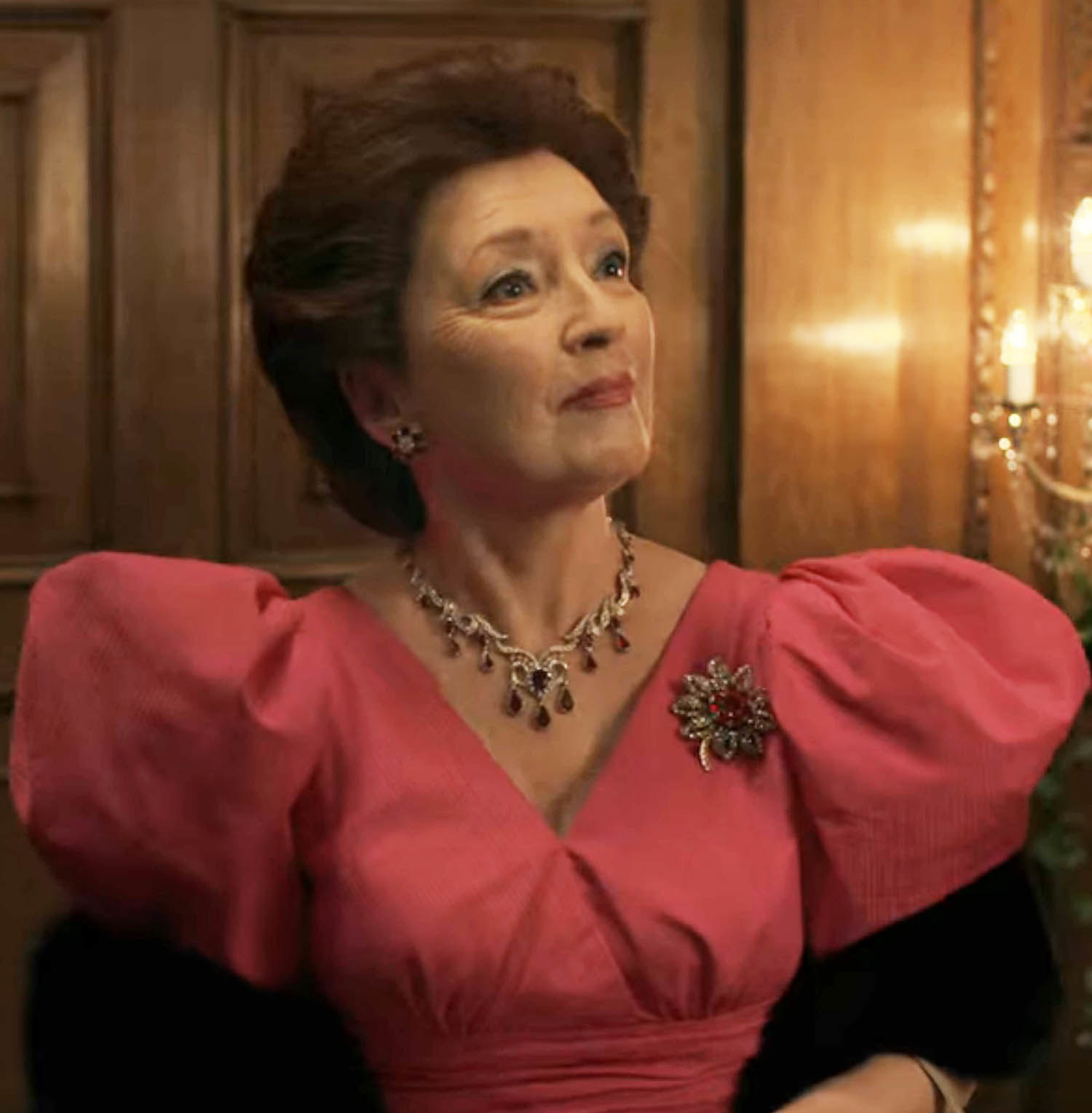 Lesley in a formal pink dress with voluminous pink shoulders and a brooch