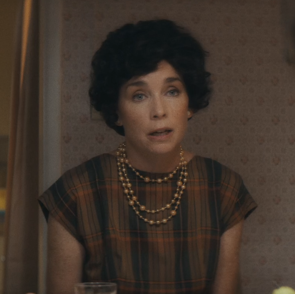 closeup of Julianne Nicholson in character wearing a very short wig and pearls