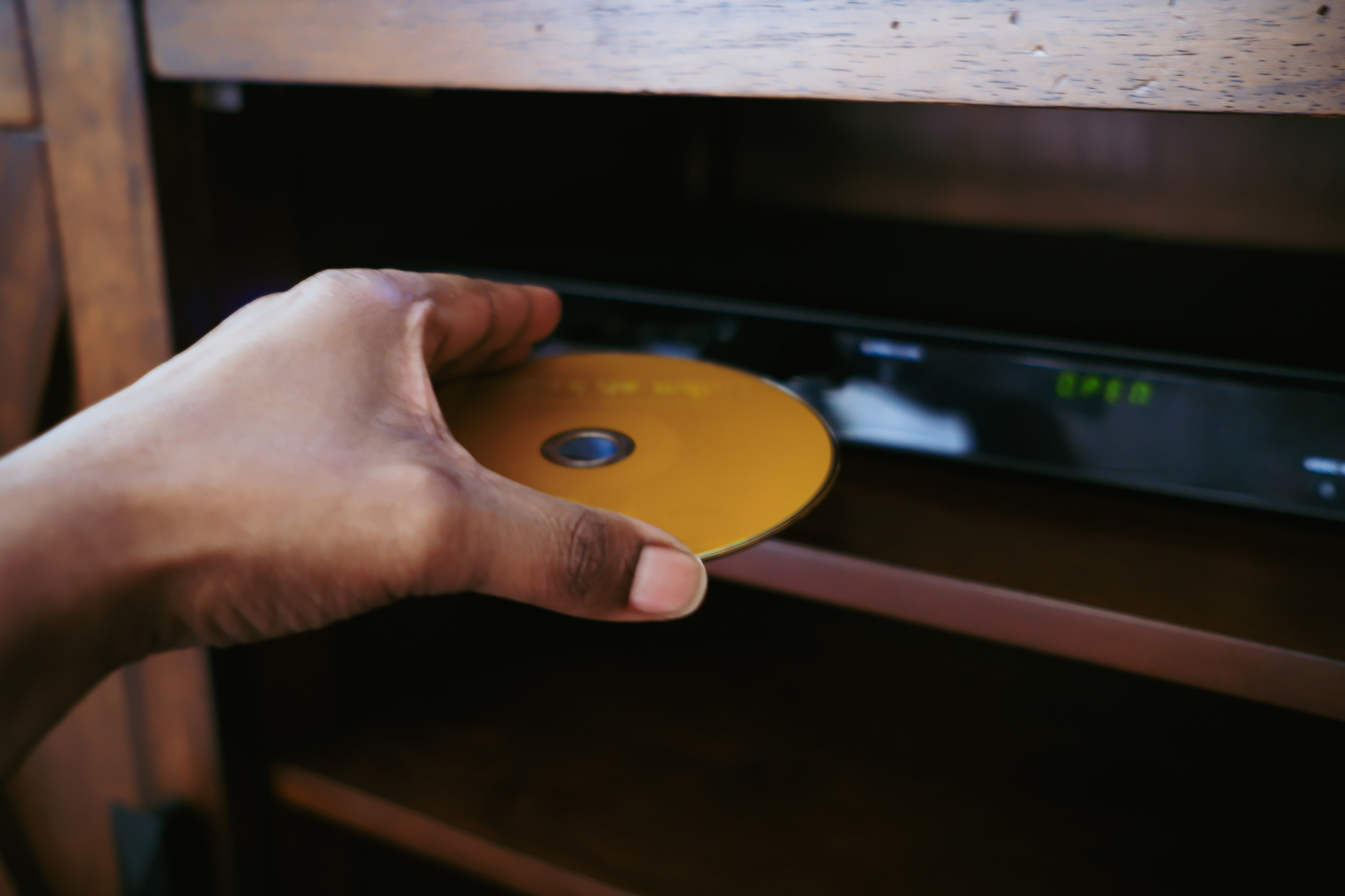 A person putting a DVD into a DVD player