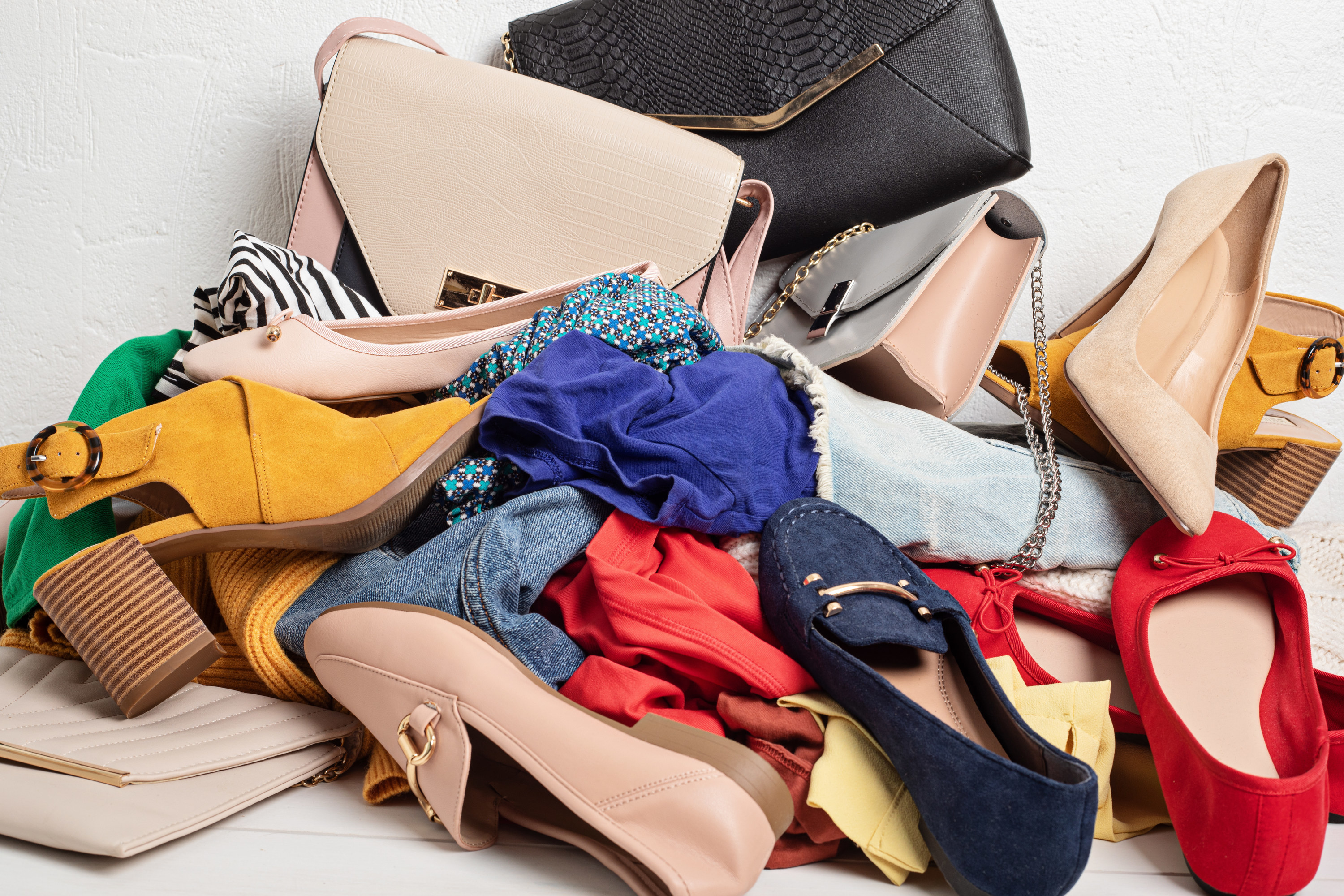 A pile of clothes and shoes on the floor