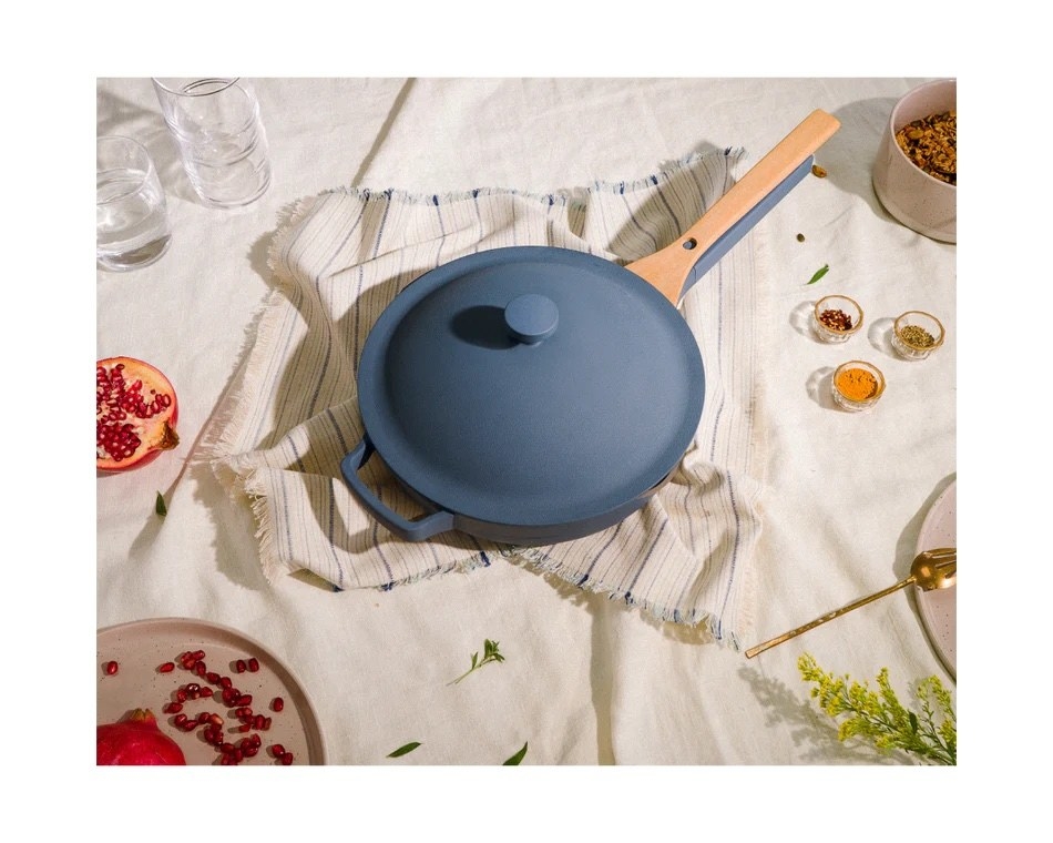 blue always pan with a lid, helper handle, and a wood spatula nested on the main handle