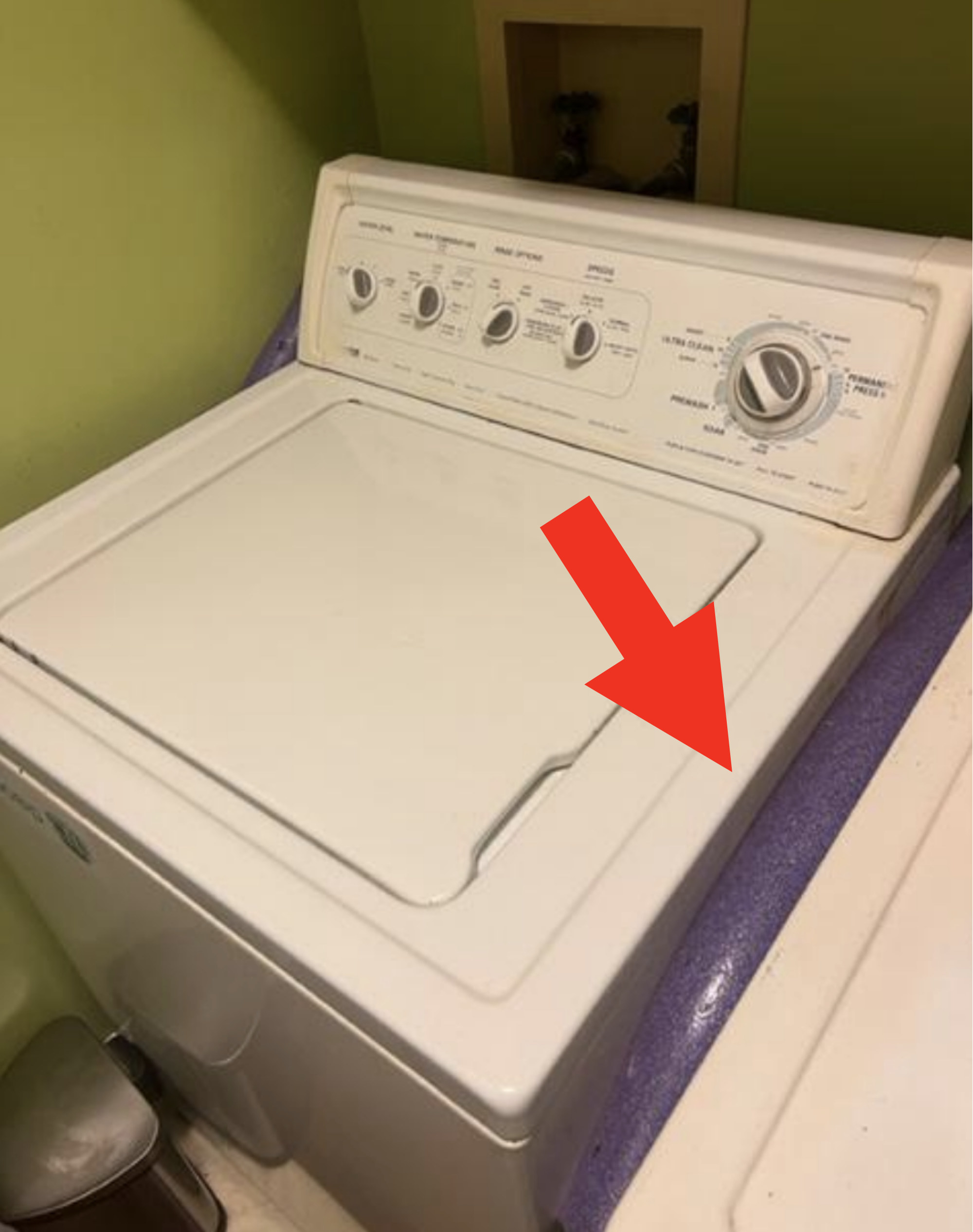 A pool noddle between a washing machine and dryer
