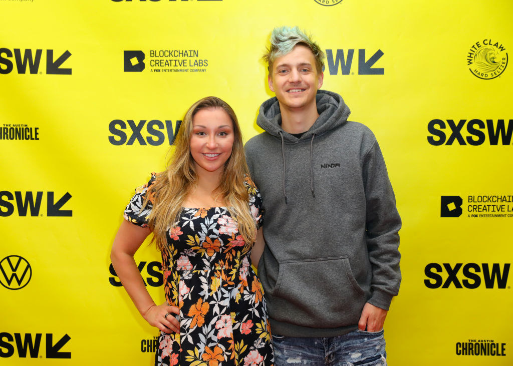 Ninja in a hoodie and Jessica in a floral dress and arm in arm