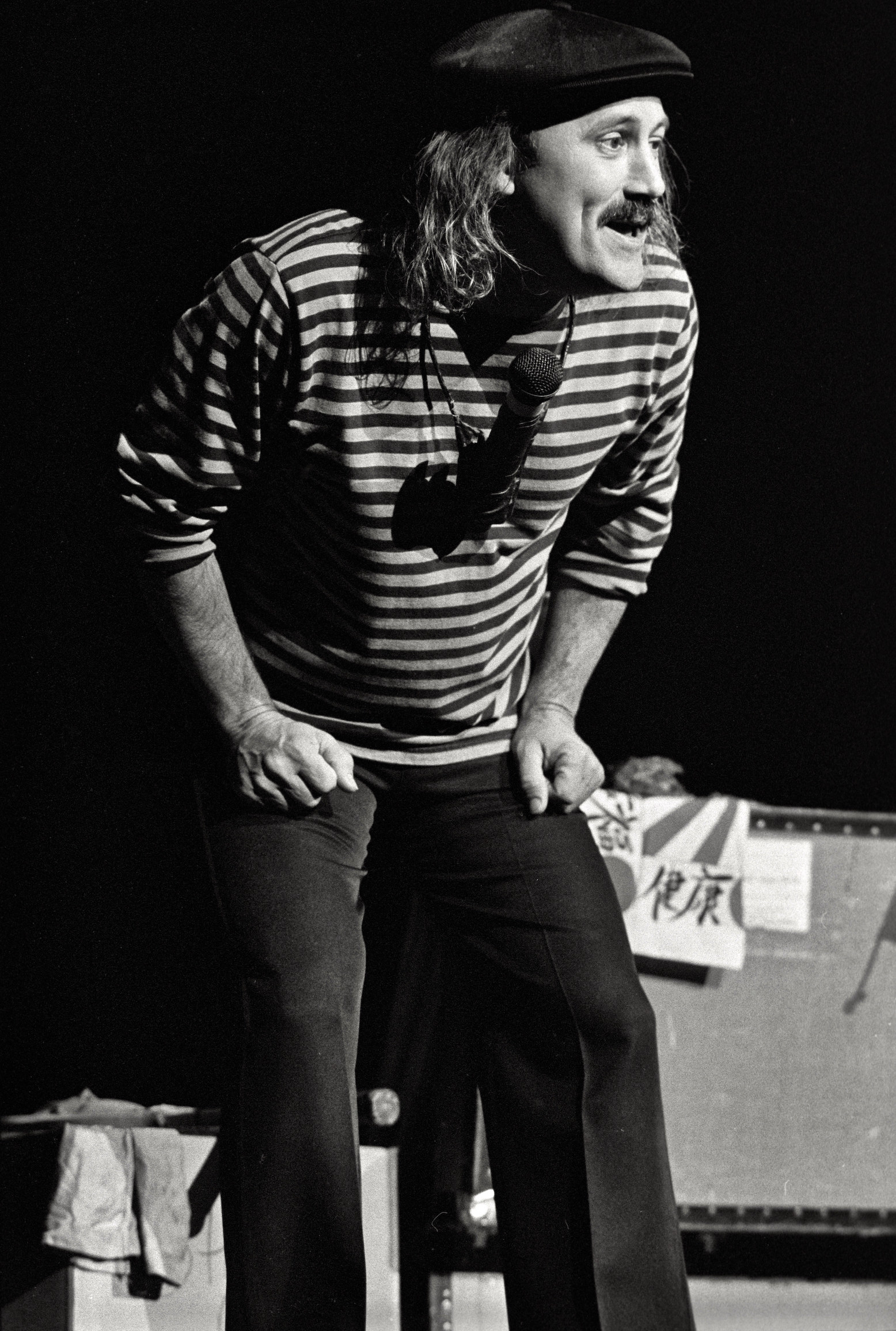 Gallagher in a beret and stripped long sleeve on stage