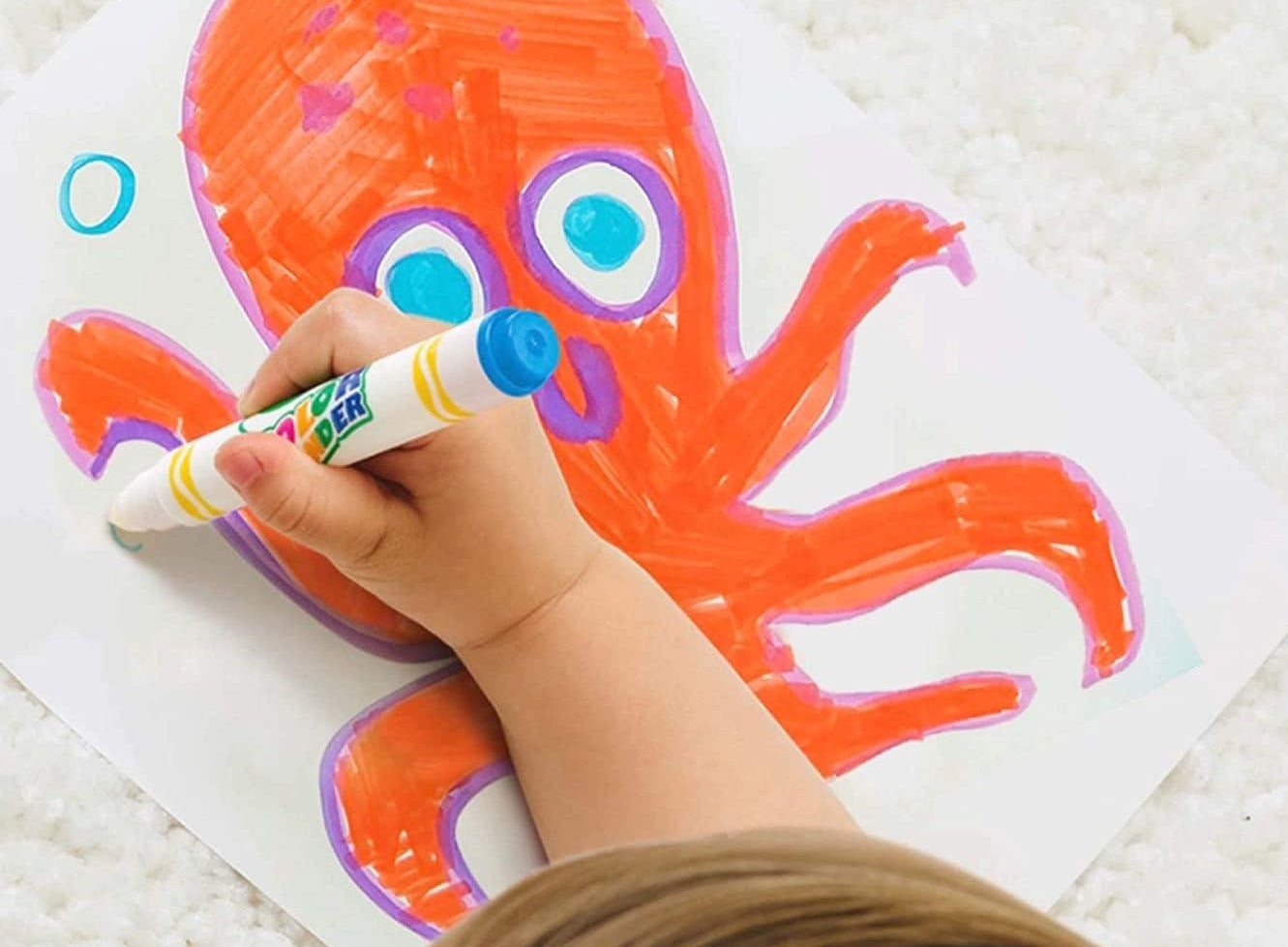 child drawing an octopus with the markers