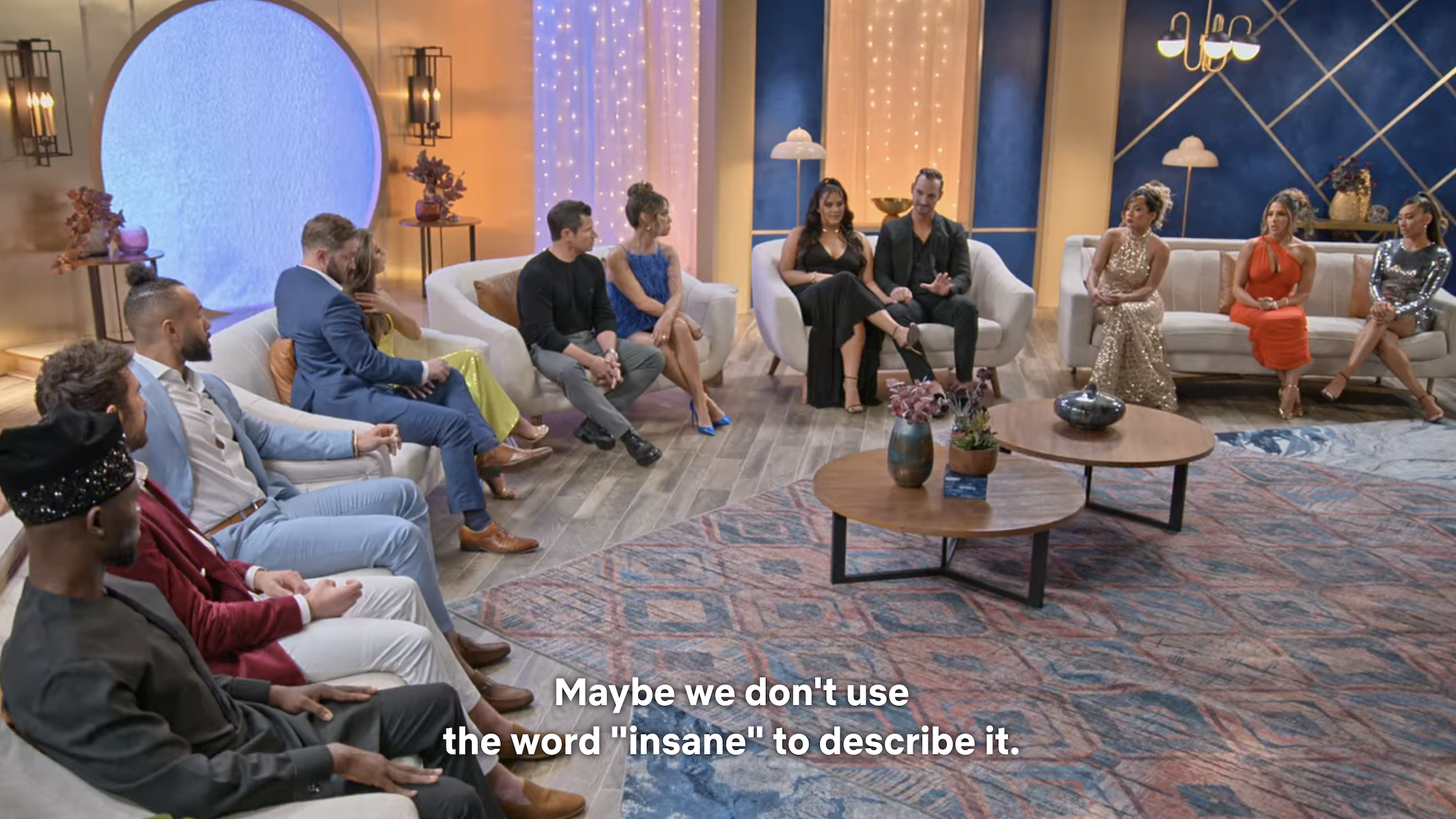 The members sitting in a semicircle on couches with the caption, &quot;Maybe we don&#x27;t use the word &#x27;insane&#x27; to describe it&quot;