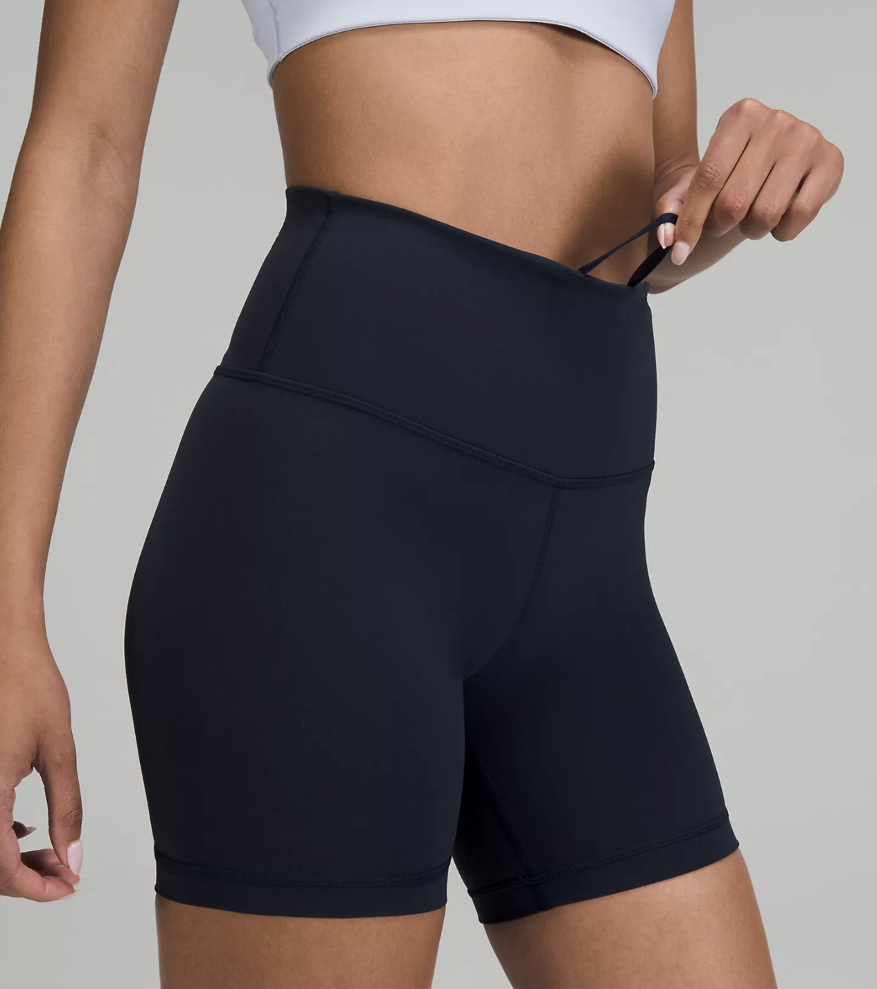A person wearing the shorts and tugging on their waistband string