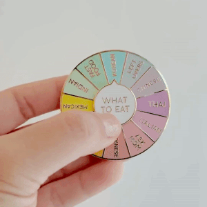 a gif of a spinning colorful pin with different food options around it