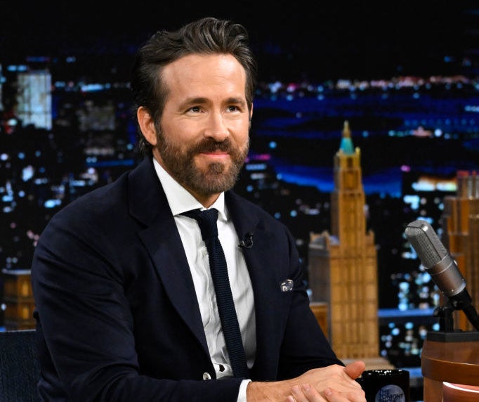 ryan reynolds sitting down in a suit on the tonight show