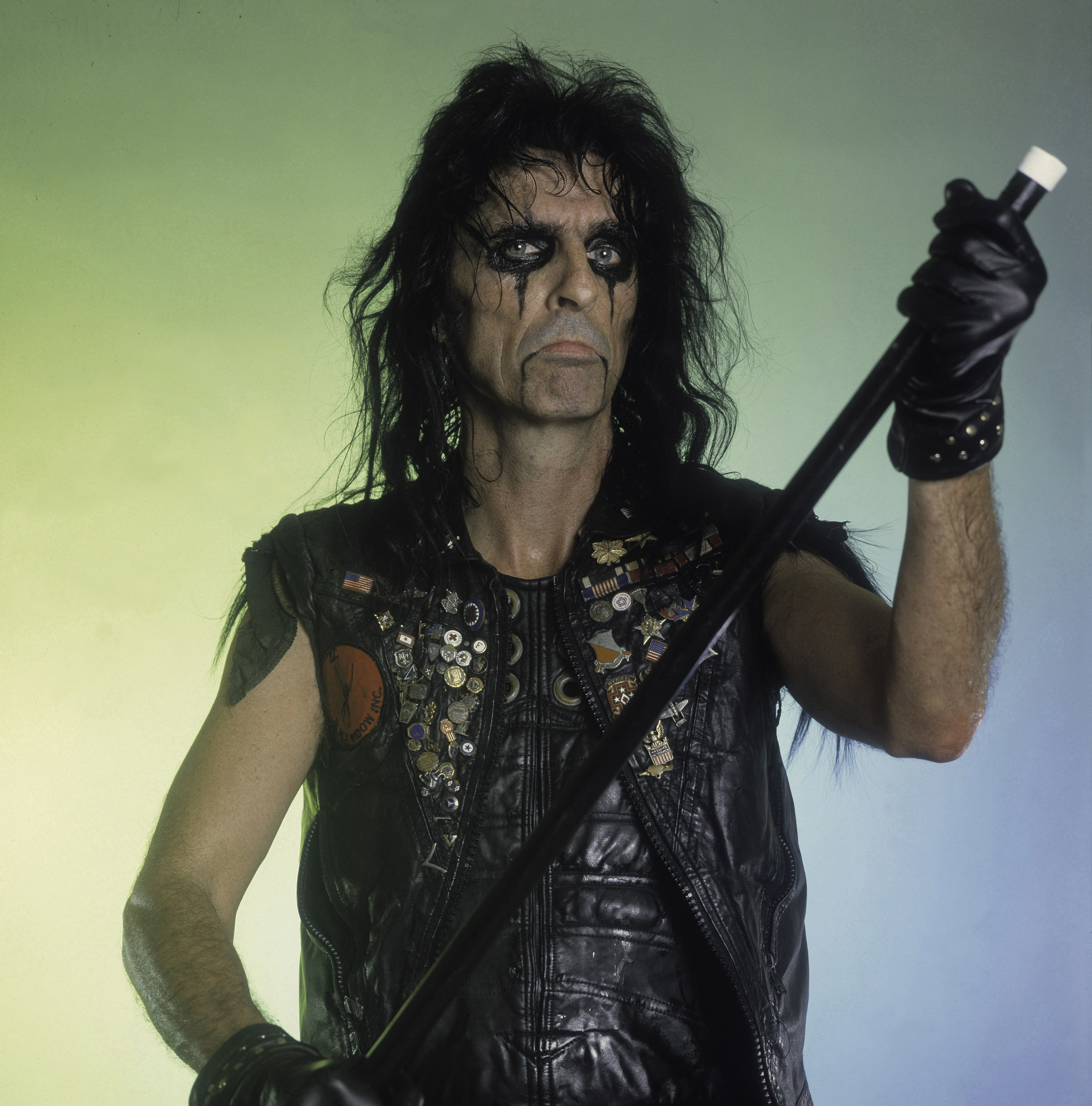 alice cooper on stage with heavy eye make up and a leather vest