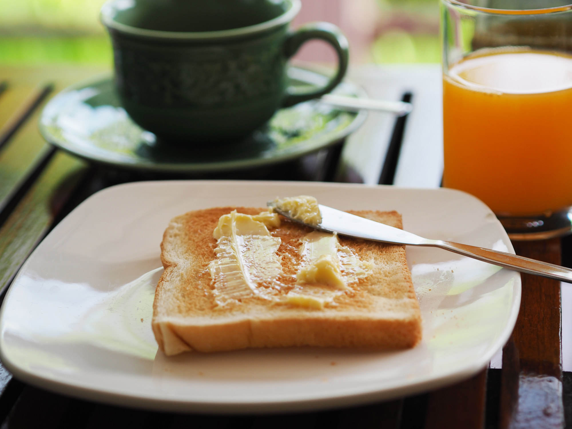 Buttered bread on white plate.