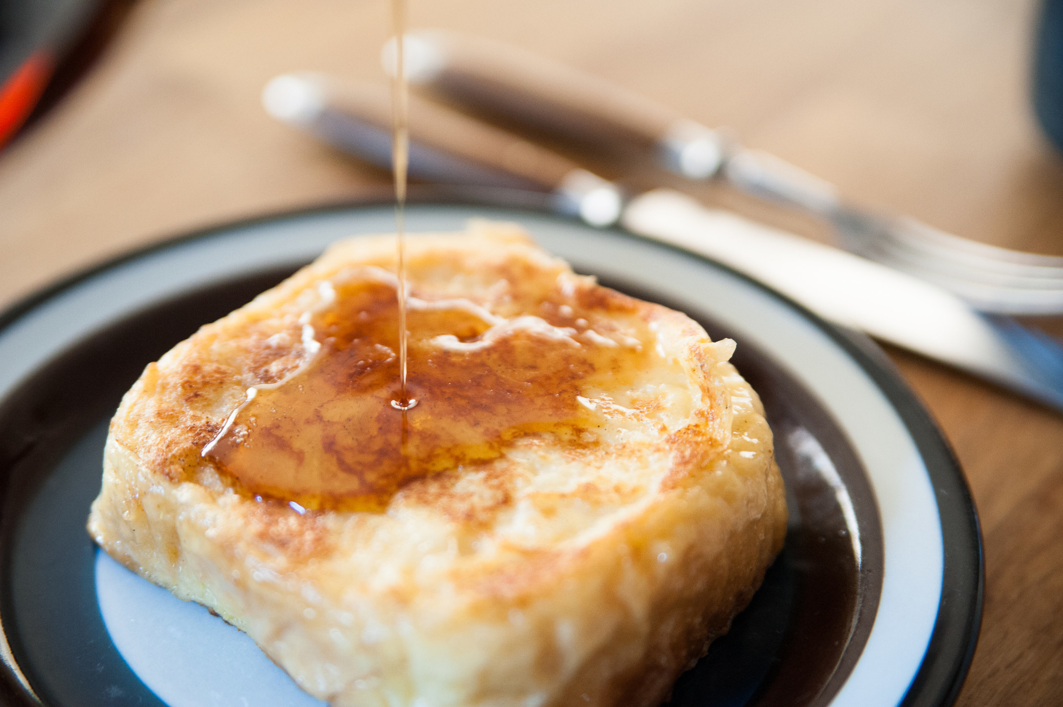 Drizzling maple syrup over French toast