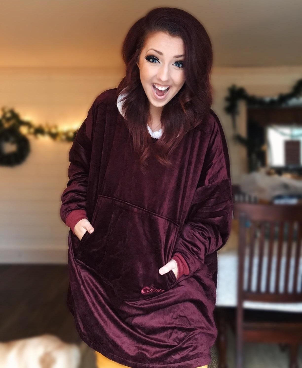 a reviewer wearing the red comfy blanket sweater
