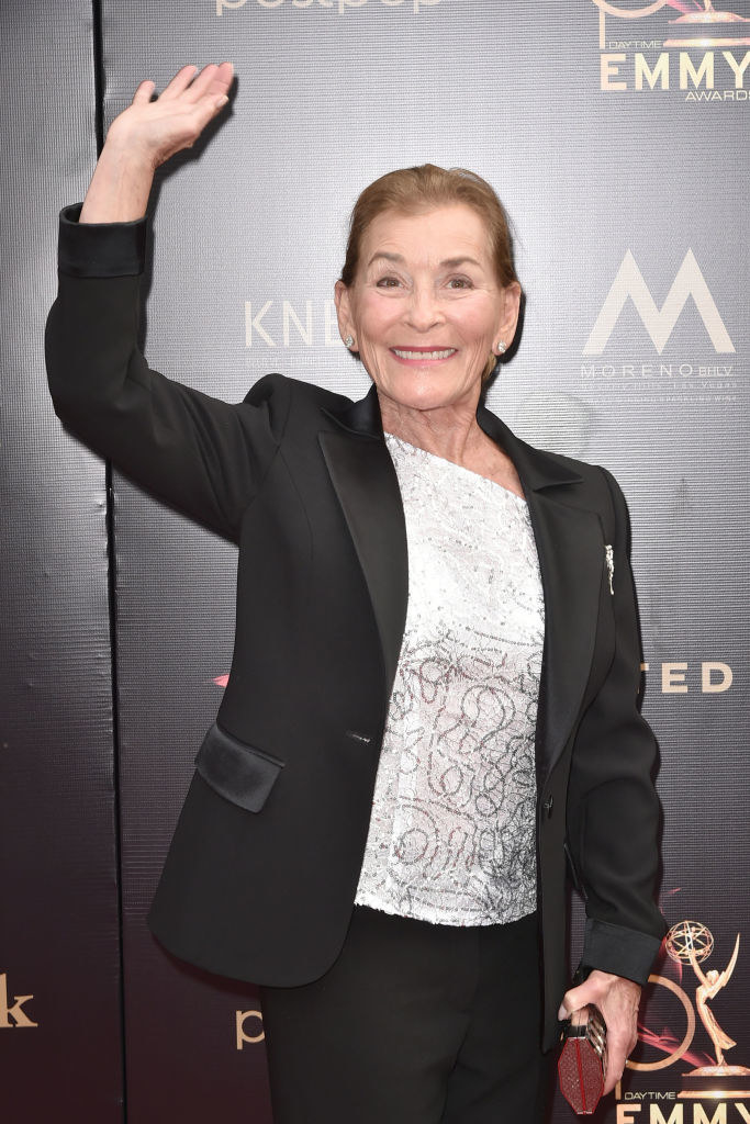 Judge Judy smiling and waving on the red carpet