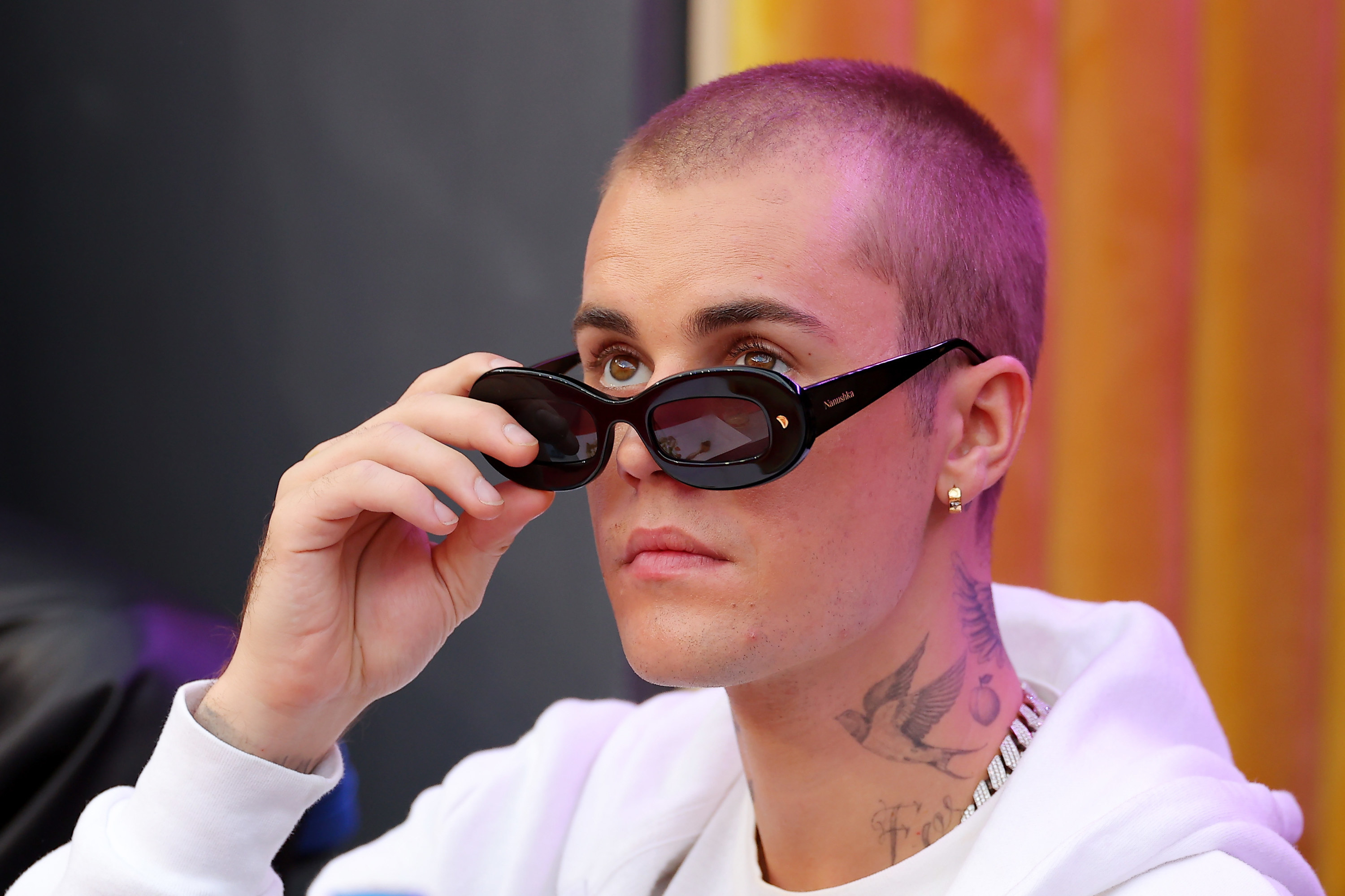 A closeup of Justin adjusting his sunglasses