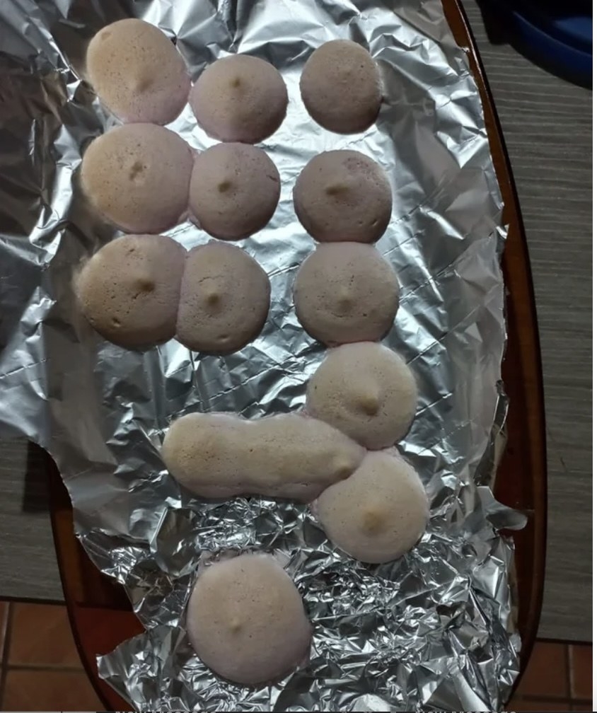 baking sheet with macroons and one shaped like a penis