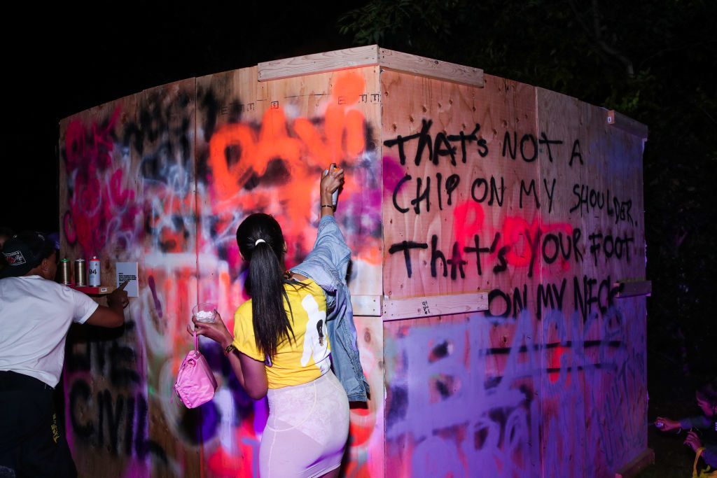 People tagging graffiti on a wall for Teyana Taylor&#x27;s album release party