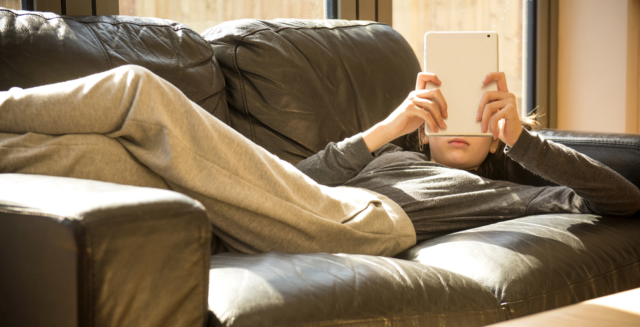 Person lying on a couch reading
