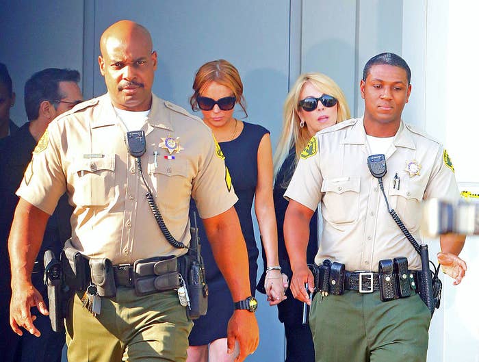 Lindsay walking with her mother behind two law enforcement officers