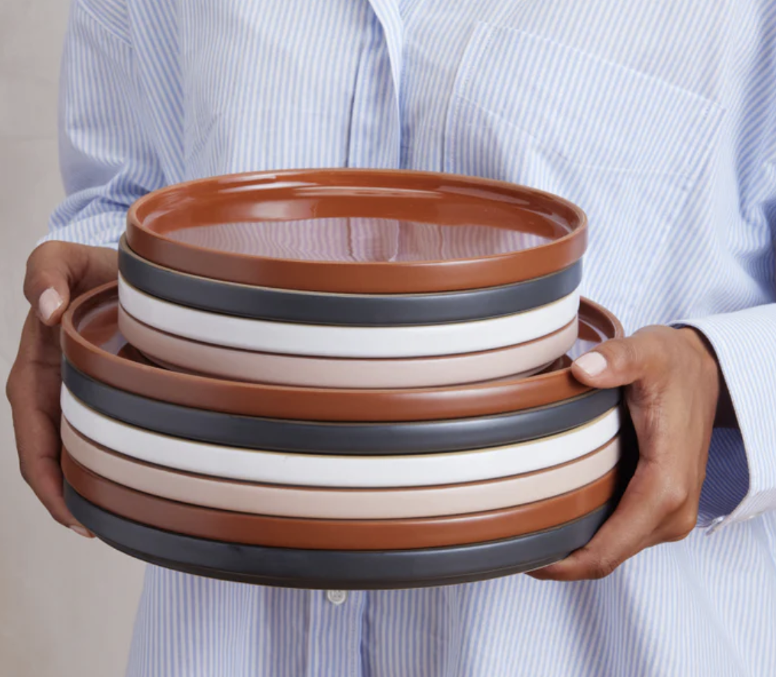 A person carrying a stack of two different size plates
