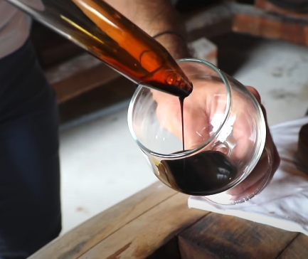 pouring thick balsamic vinegar into a tasting glass