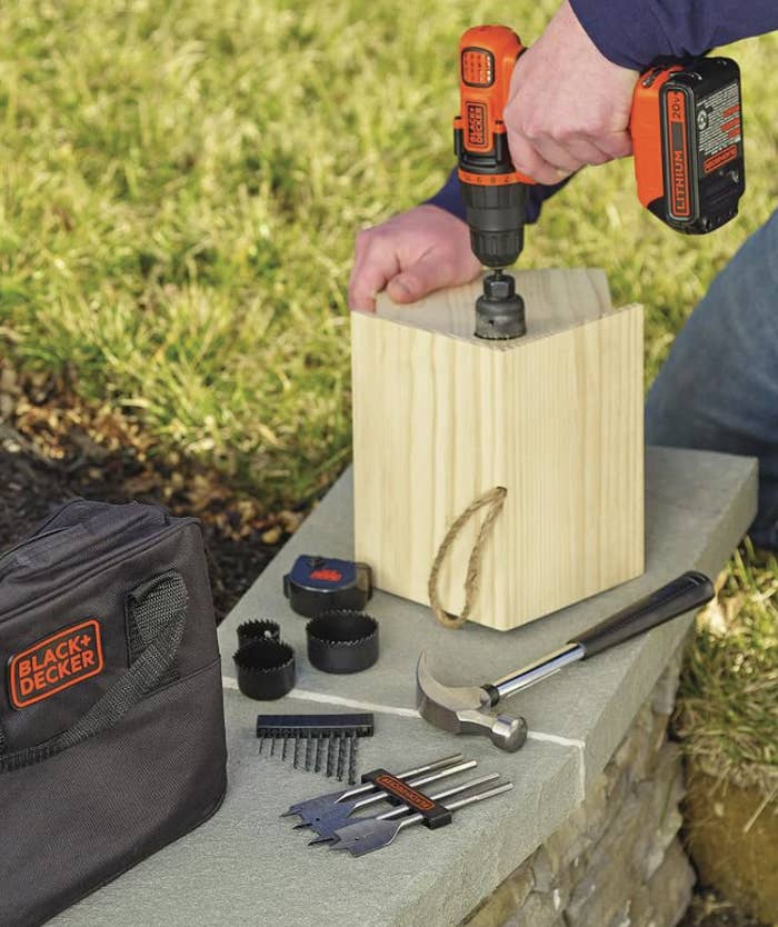 A person using the drill to make a birdhouse