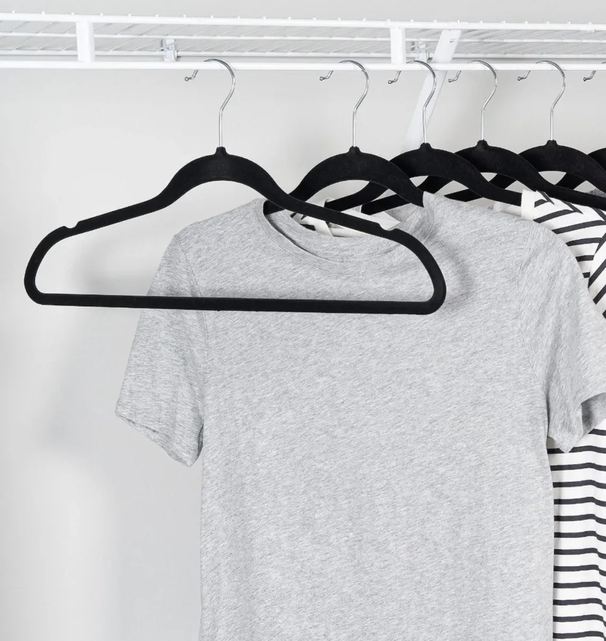 the felt hangers in a closet with shirts on them