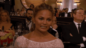 Chrissy Teigen looking uncomfortable at the Golden Globes