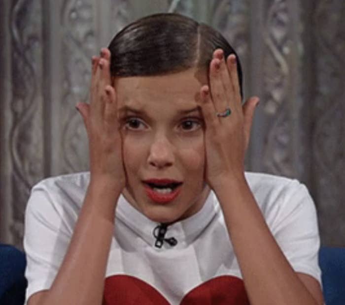 a girl holding her head looking scared