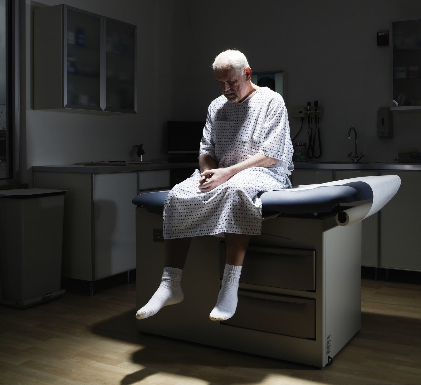 A man sitting on a bed in a doctor&#x27;s office