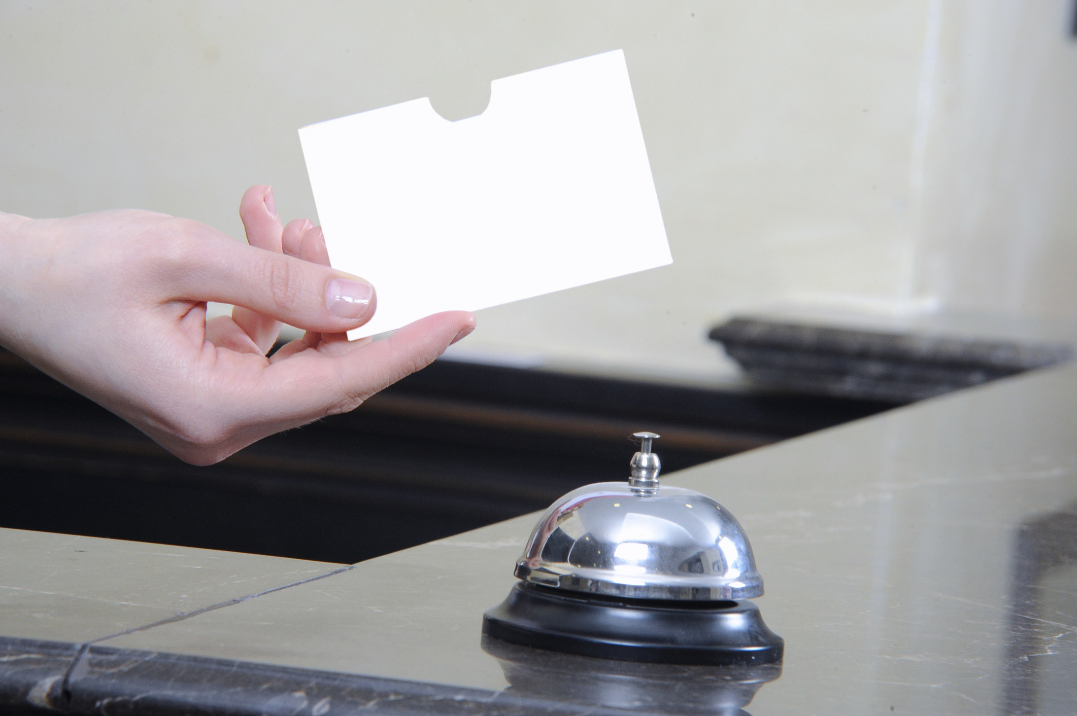 Hotel desk handing a card to a patron