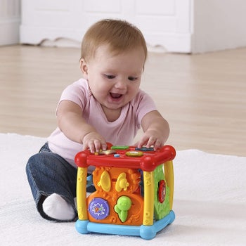 A baby playing with the activity cube