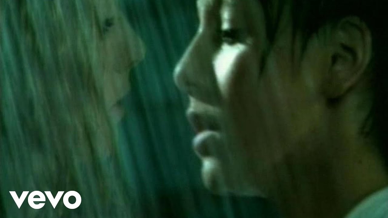 A close up of two girls who are about to kiss in the pouring rain