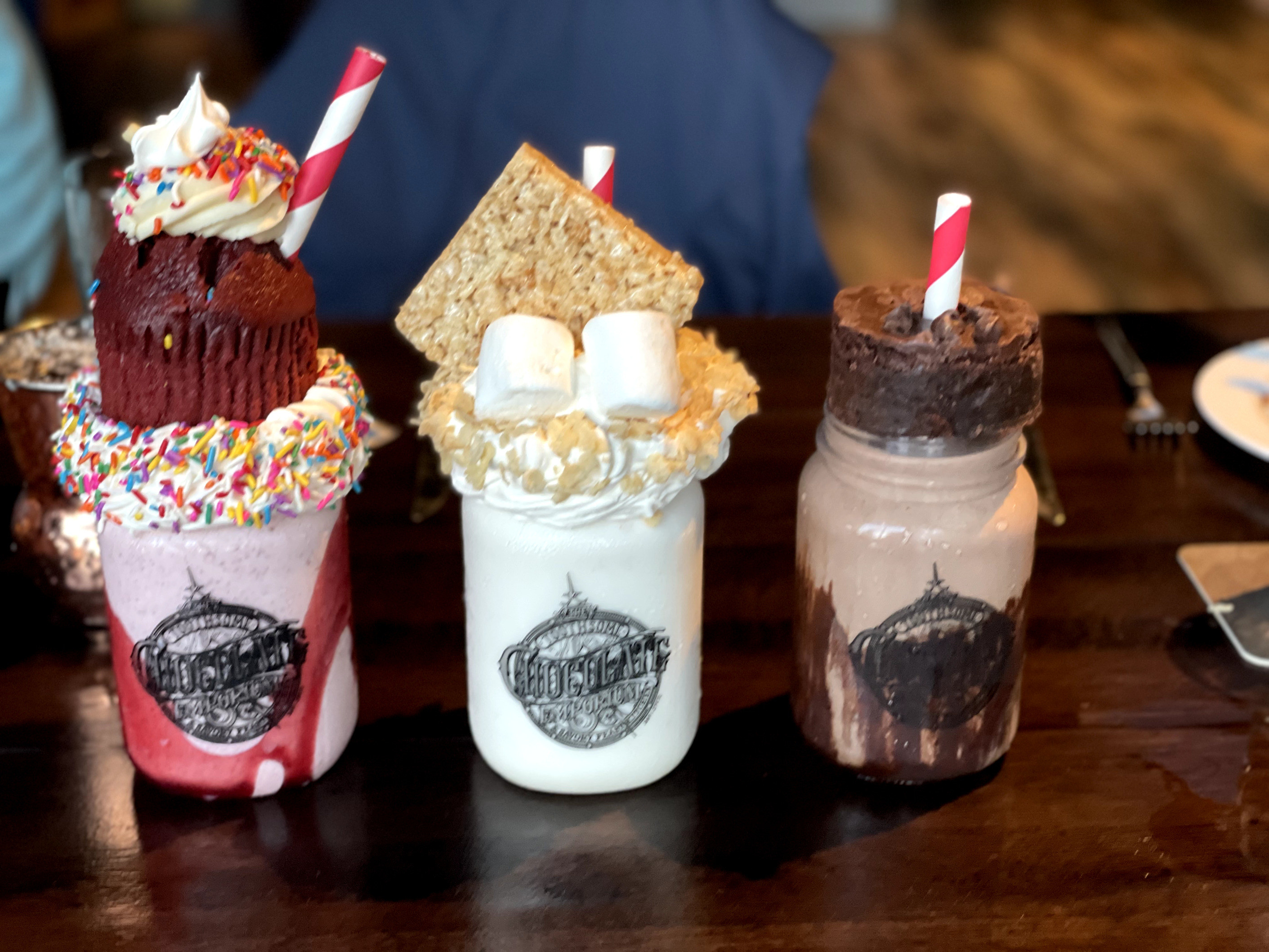 A photo of three milkshakes on a table