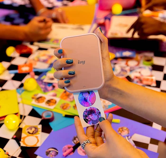 A person taking stickers out of the photo printer