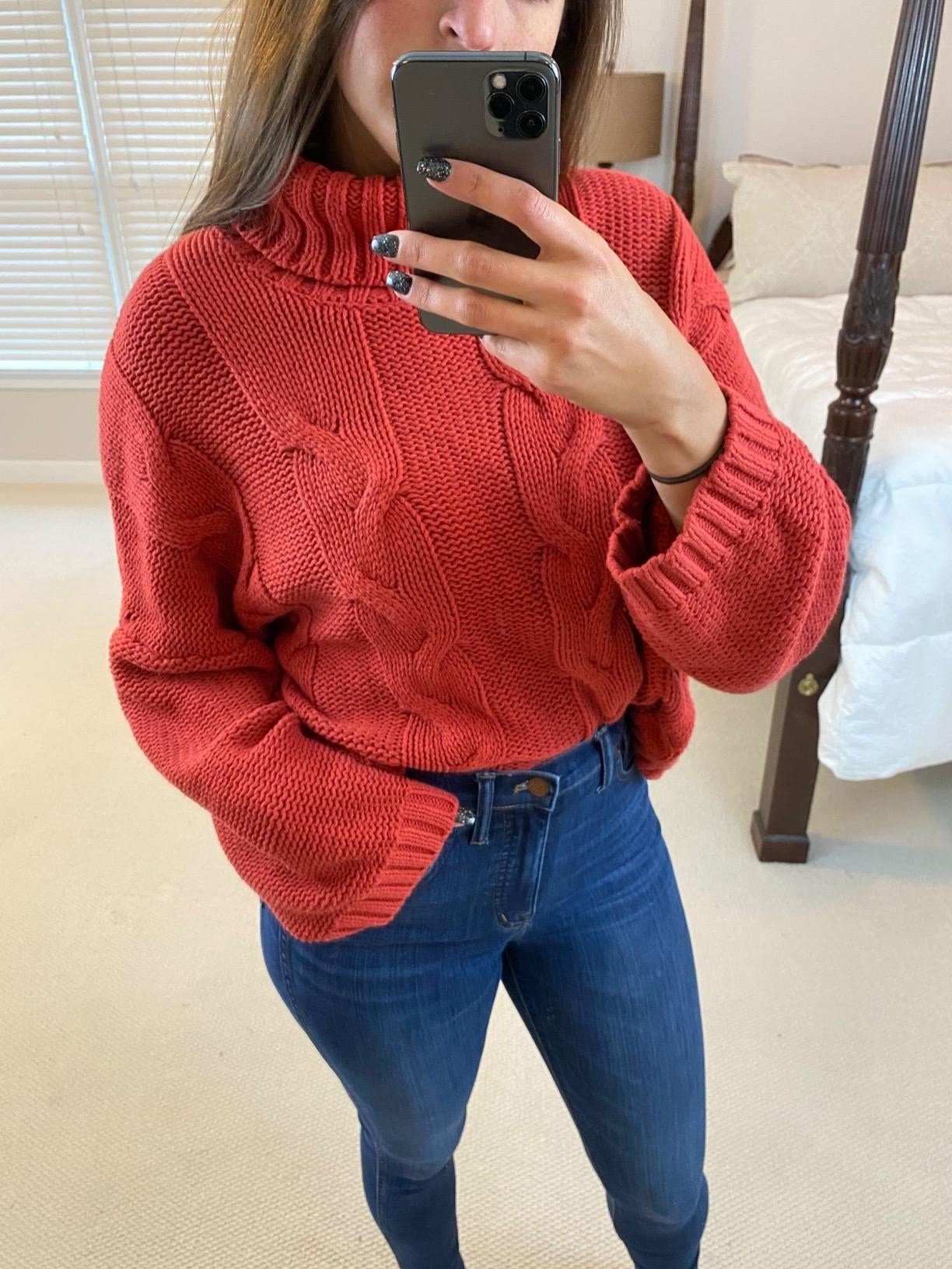 reviewer in a cabled wide-sleeved red turtleneck