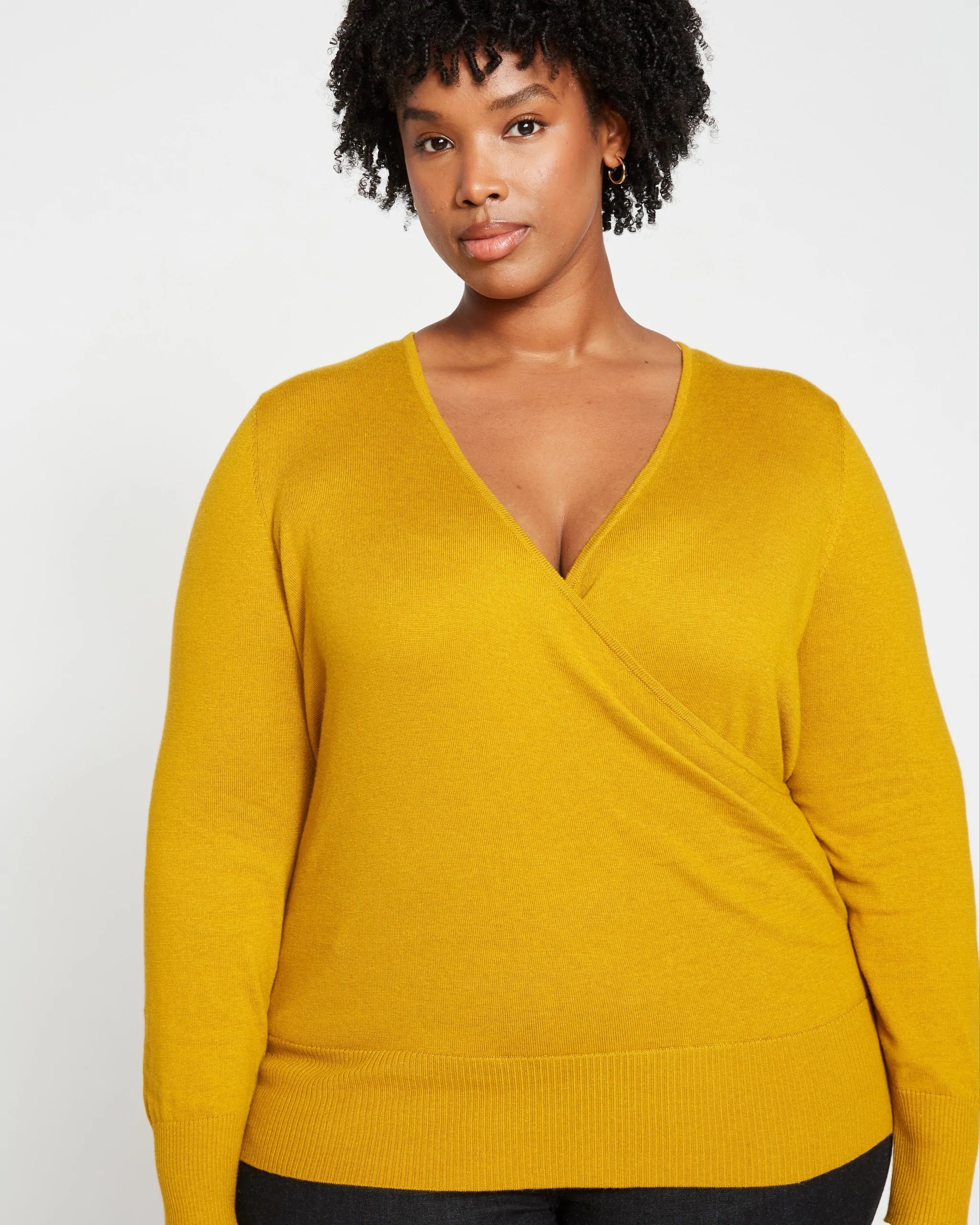model in yellow wrap sweater