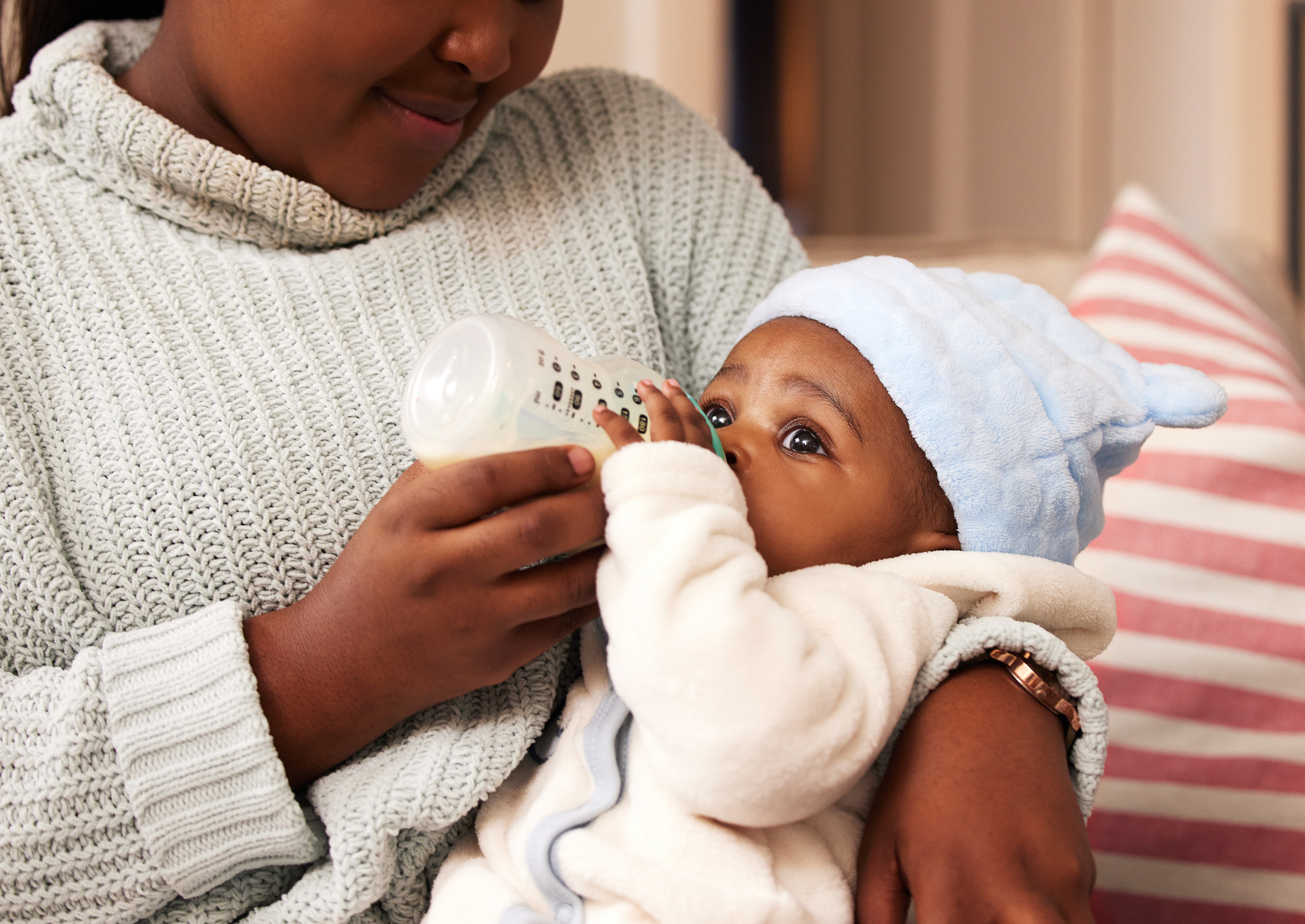 a woman feeding her baby with the bottle