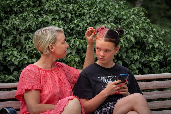 a woman touching their daughters hair outside