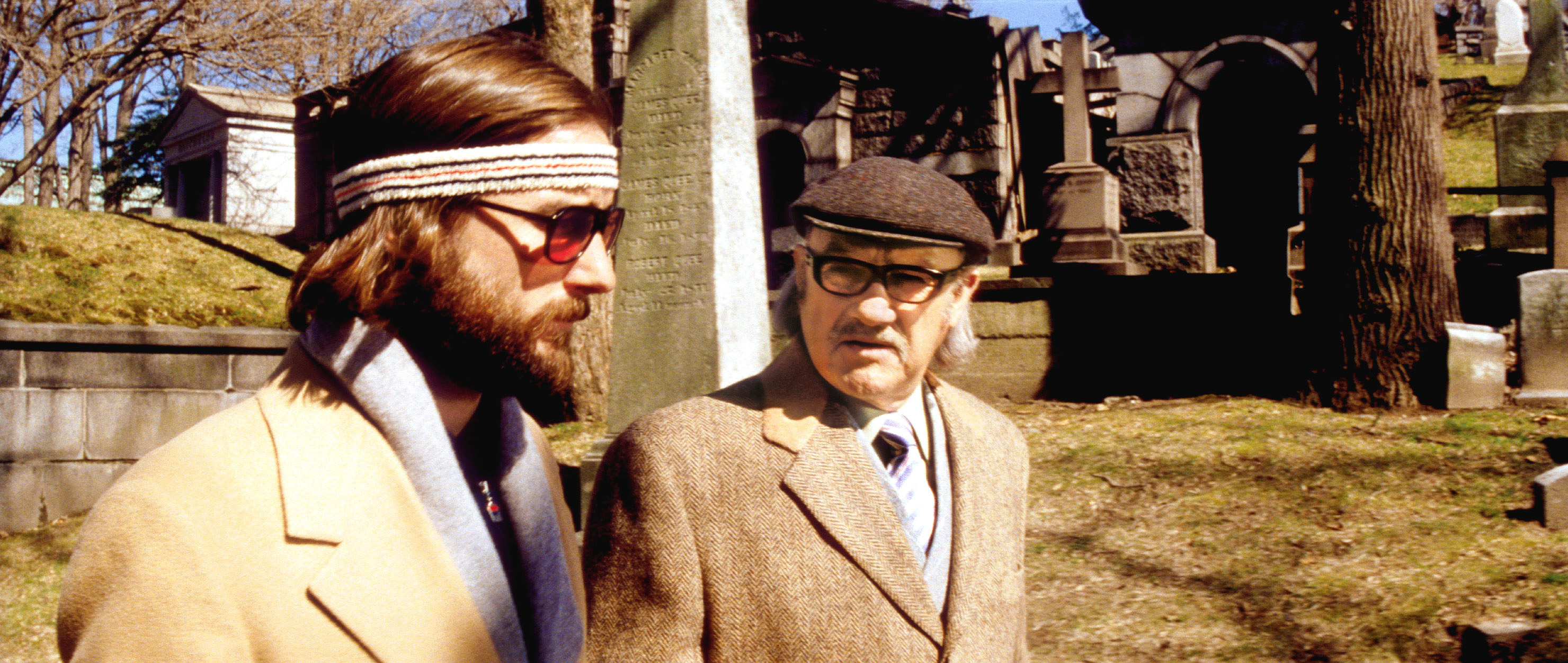 Luke Wilson and Gene Hackman walking in a cemetery.
