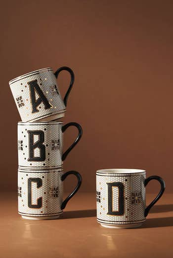 four mugs with different letters on the front
