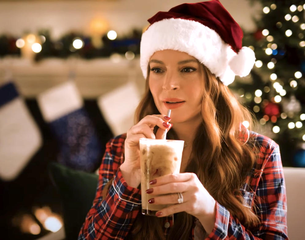 Lindsay sipping Pepsi milk and wearing a Santa hat