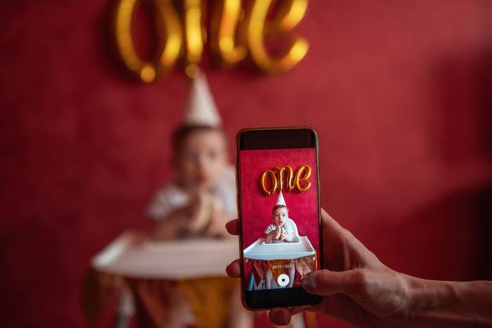 woman taking a staged baby photo on her child's first birthday