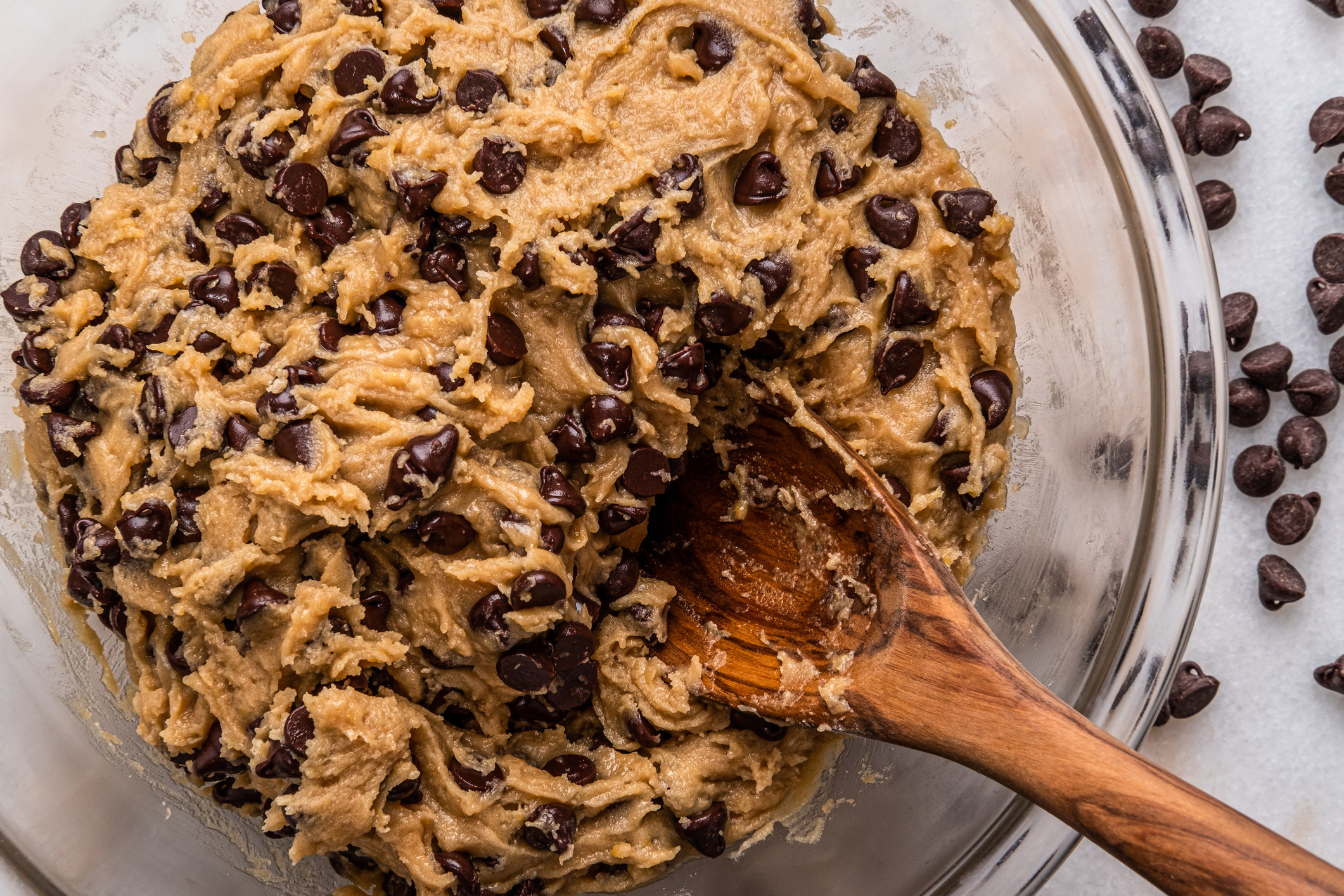Chocolate Chip Cookie Batter in a bowl with a wooden spoon
