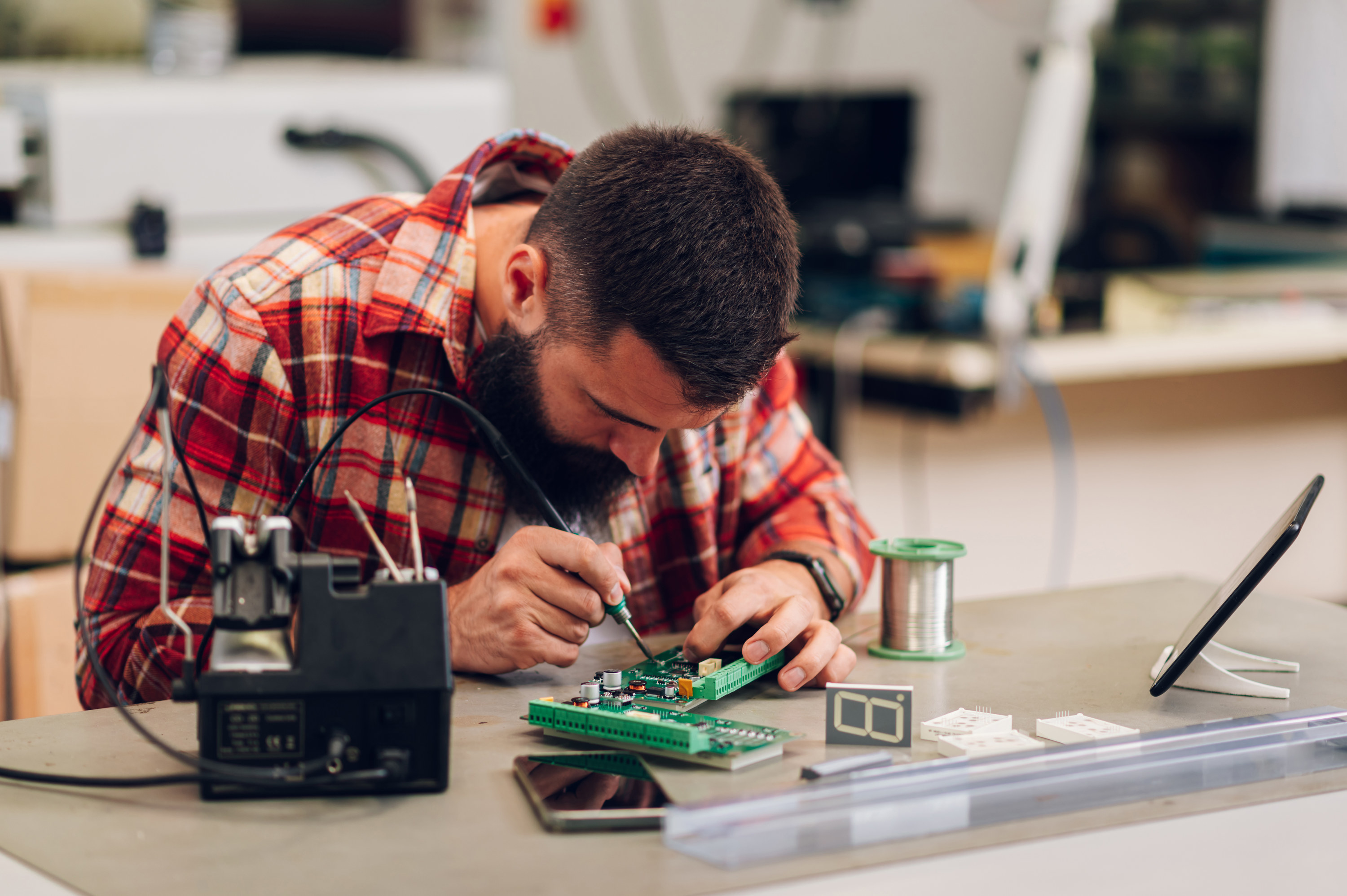 A man fixing a small part of a computer