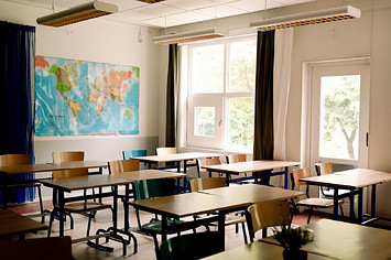 Desks and chairs arranged in classroom at high school