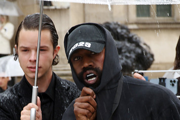 Ye is seen having an umbrella held over him