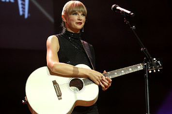 Taylor Swift is seen holding a guitar