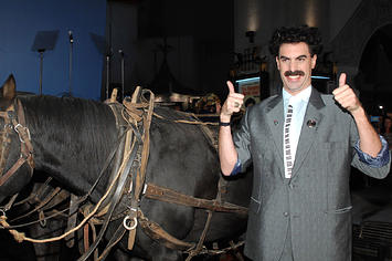 Borat poses in front of the Kazakhstan flag